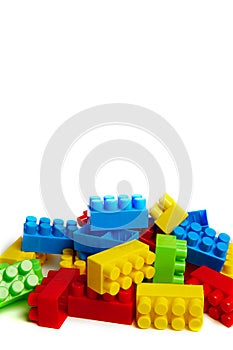 Multi-colored plastic designer building blocks on a white background. Colorful construction kit for kids