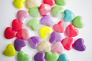 Multi-colored plastic hearts on a white background. Background for Valentine\'s day