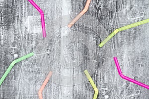 Multi colored plastic straws on black grunge background