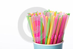 Multi colored plastic straws in disposable paper cup isolated on white backdrop