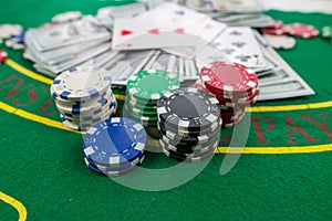 Multi-colored poker cards, chips, dollar bills, on a new green poker table. Poker concept