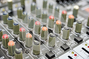 Multi-colored potentiometers on a mixing console, close-up