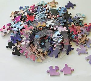 Multi colored puzzle pieces on a white surface