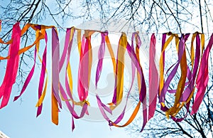 Multi-colored ribbons flutter against the background of the blue sky