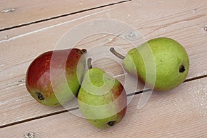 Multi-colored ripe pears on background of boards.