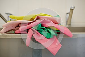 Multi-colored rubber gloves for cleaning are in the kitchen