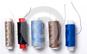 Multi-colored sewing threads on a light background, top view. Close-up.