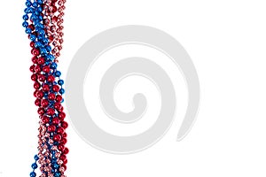 Multi colored shiny mardi gras beads on white background