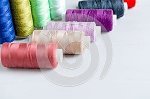 Multi-colored spools of sewing threads close-up. Craft and hobby concept