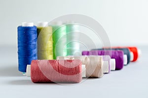 Multi-colored spools of sewing threads close-up. Craft and hobby concept