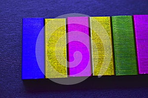Multi-colored stapler staples on a black background