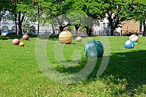 Multi-colored stone spheres lie on a lawn. Braniewo, Poland