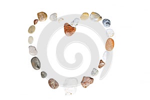 Multi-colored stones laid out in the shape of a heart on the isolated on white background. Romance and relaxation. Close-up
