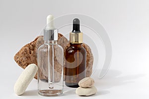 Multi-colored stones with a transparent bottle with a pipette on a white background.