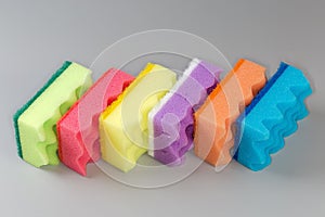 Multi colored synthetic cleaning sponges on a gray background