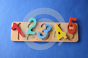 Multi colored toy numbers at blue background with copy space