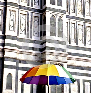 Multi colored umbrella in front of the cathedral of Siena