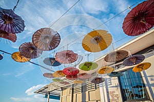 Multi-colored umbrellas hung on decorative wire to decorate the