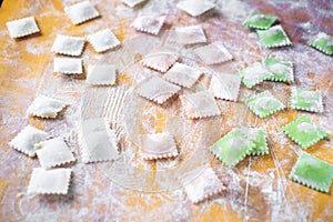 Multi-colored uncooked ravioli on a cutting board