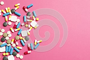 Multi-colored vitamins on a pink background