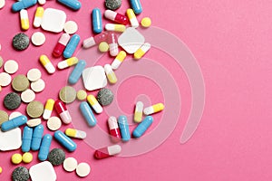 Multi-colored vitamins on a pink background