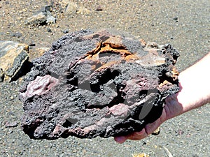 Multi-colored volcanic stone in a man\'s hand