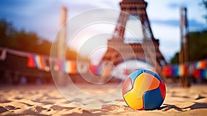 A multi-colored volleyball lies on sand against the backdrop of the Eiffel Tower during sunset, Summer Olympics in 2024