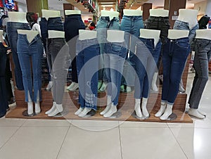 Multi-colored women's trousers on mannequin in a clothing store.