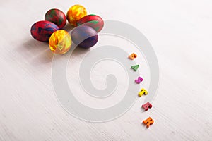 Multi-colored wooden letters making up the words happy easter and decorative colourful eggs on a white background with