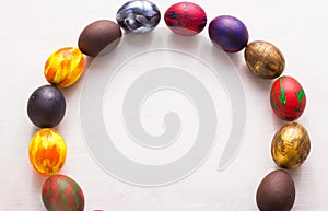 Multi-colored wooden letters making up the words happy easter and decorative colourful eggs on a white background with