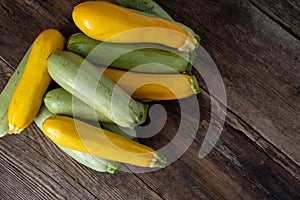 Multi-colored zucchini yellow, green, white, orange on the wooden table close-up. Food background. Fresh harvested