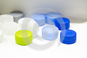 The multi-colors plastic bottle caps on the white background.