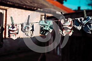 Multi colors socks anre hanging on the rope.