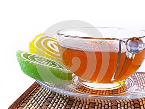 Multi-coloured fruit candy and cup of hot tea