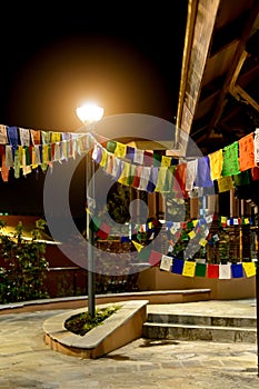 Multi-coloured rag tags of a garland are hanged out on cords in one of the Chinese