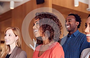 Multi-Cultural Business Team Standing In Modern Open Plan Office Together