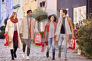 Multi Cultural Couple With Friends Sale Shopping In City Carrying Bags In Fall Or Winter