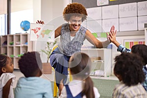 Multi-Cultural Elementary School Pupils With Female Teacher In Geography Class  At School