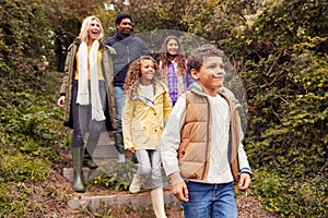 Multi-Cultural Family Walking Down Steps In Countryside On Winter Beach Vacation