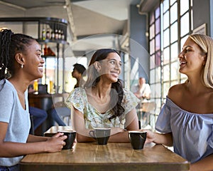 Multi-Cultural Group Of Female Friends Meeting And Catching Up In Restaurant Or Coffee Shop 
