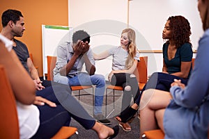 Multi-Cultural Group Of Men And Women At Mental Health Group Therapy Meeting