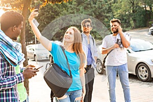 The multi-cultural students with smartphones walk in the city