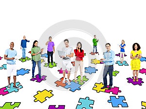 Multi-Ethinic People Standing On Jigsaw Puzzle Pieces photo