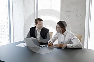 Multi ethnic business partners working on collaborative project at workplace