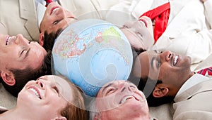 Multi-ethnic business team lying around a globe
