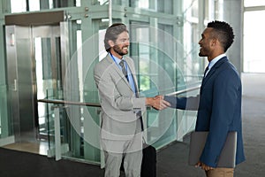 Multi-ethnic businessmen shaking hands with each other in the corridor