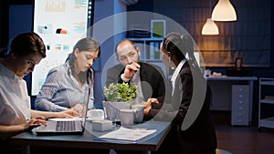 Multi-ethnic businesspeople discussing financial company solution sitting at conference table