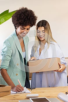 Multi-ethnic colleagues sending parcel to customer