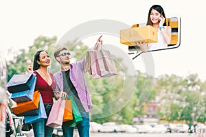 Multi-ethnic couple with shopping bag, man point young small business owner, sell goods on mobile phone call. E commerce concept