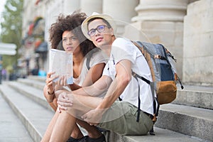 Multi-ethnic couple tourists with map in city